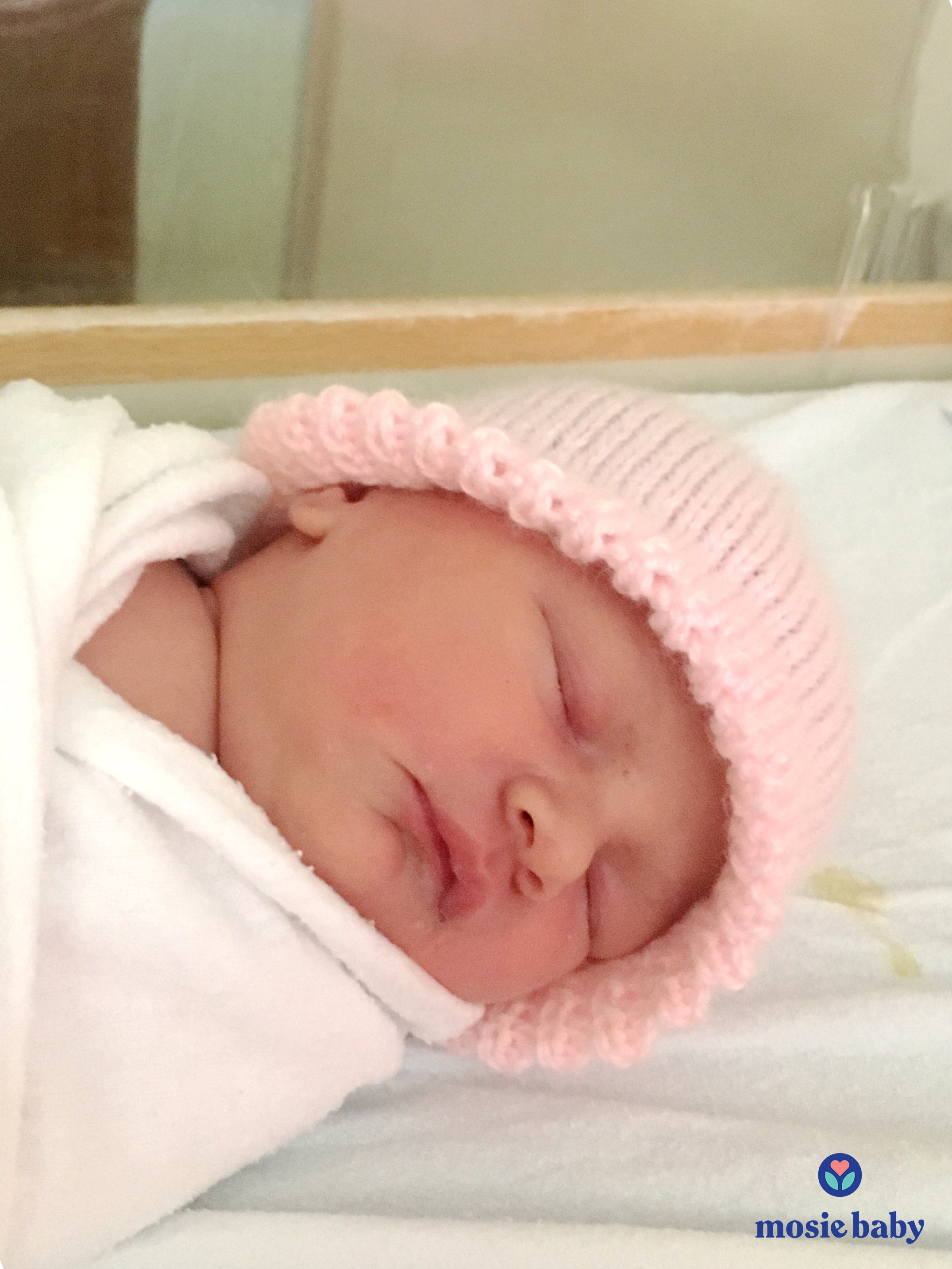 newborn baby with a pink hat