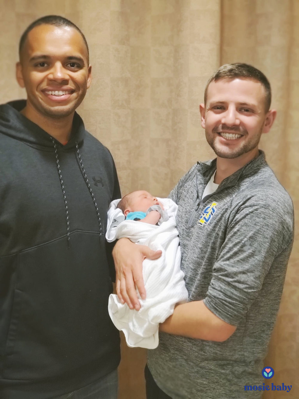 two dads with their newborn mosie baby